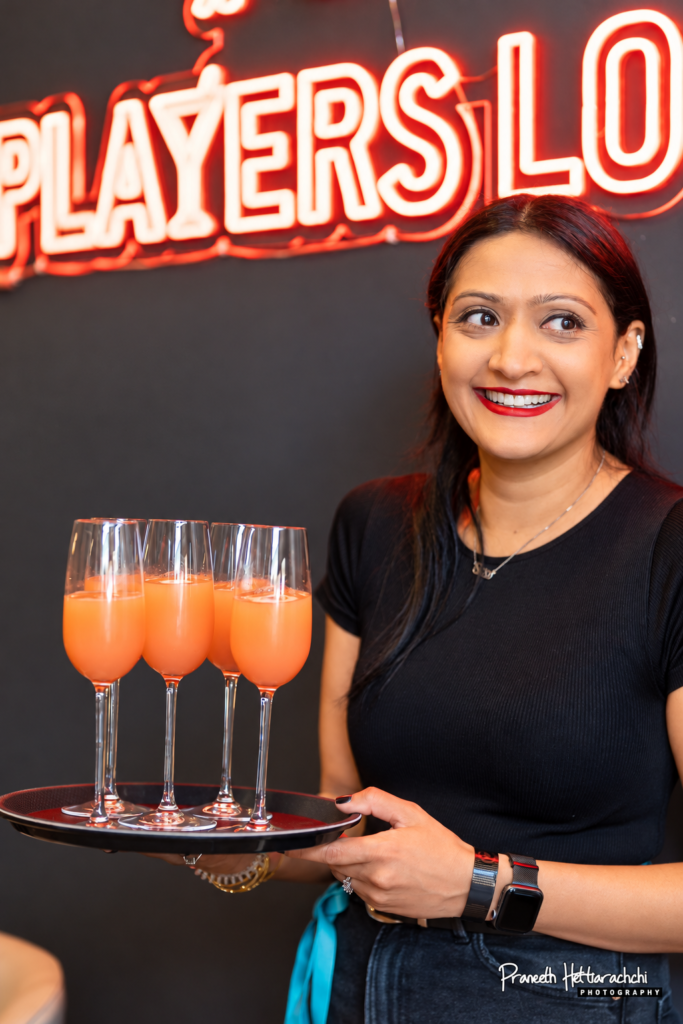 Guest holding a tray of cocktails at HPC Players Lounge