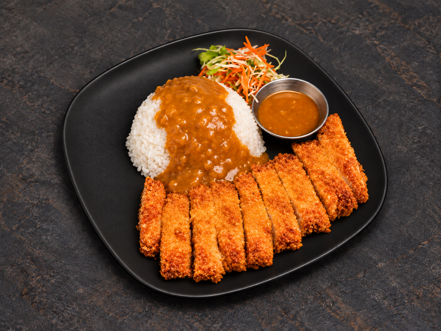 Chicken katsu with Java curry gravy over rice on a black plate
